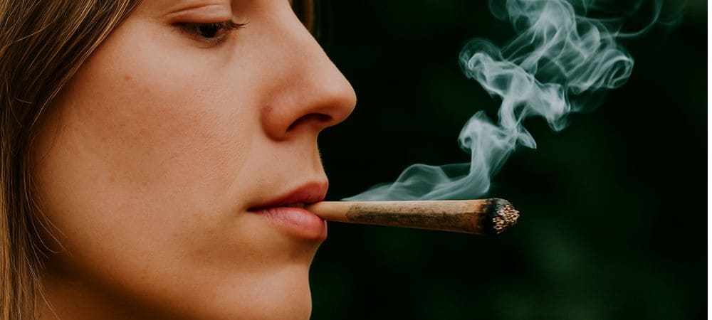 femme fumant un joint de cannabis à l’extérieur